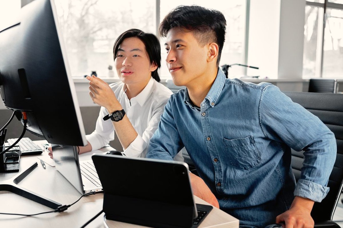Two teammates checking data on screen